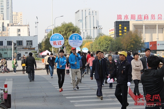 河南交通廣播的主持人們引導過馬路的行人從斑馬線通行 河南交通廣播的主持人們引導過馬路的行人從斑馬線通行