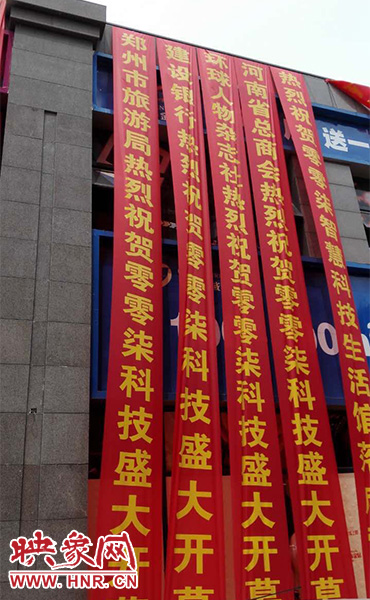 路邊一棟樓上懸掛著二三十條紅色條幅，全部是祝賀一家公司開(kāi)業(yè)的。