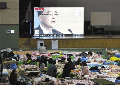27日，韓國珍島，“歲月”號客輪乘客家屬在體育館觀看總理鄭烘原辭職新聞。當日，鄭烘原召開緊急發布會，表示對韓國“歲月”號沉船事件負責，宣布引咎辭職。