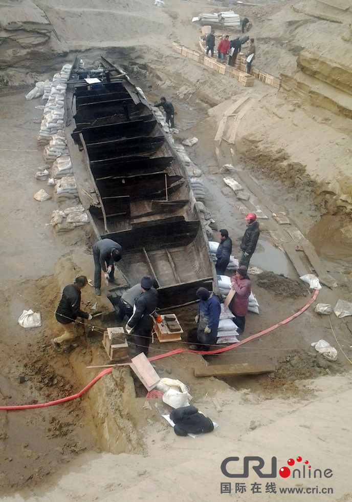 2014年1月6日，河南洛陽古沉船發掘現場，為防止古沉船受損，考古人員正在為其抹藥水。