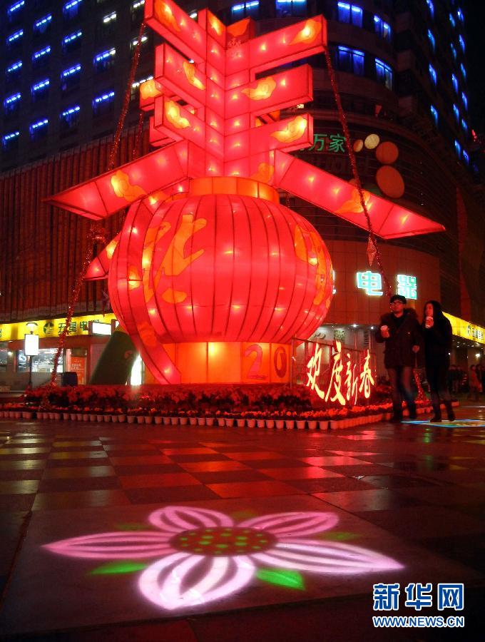 　1月30日晚，市民從蘇州市石路銀河廣場上大型“春”字彩燈景觀旁經(jīng)過。