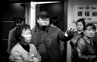 昨日，在河北香河天下第一城，相關負責人（左二）走出會議室與參加演出的老人們溝通。