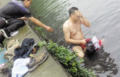 網(wǎng)友貼出民警張光聰一出河水就睜不開(kāi)眼，用手抹去臉上臟水的照片。