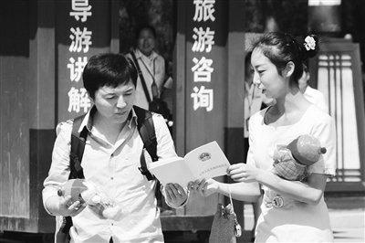 9月13日，西安臨潼華清池景區服務人員向游客介紹《旅游法》。