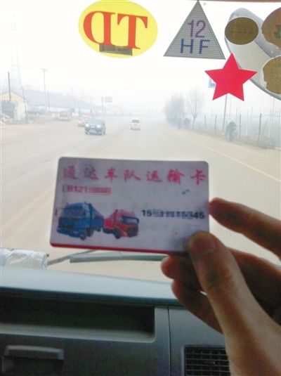 12月8日，遷西司機張田車上的“車隊”聯系卡，貨車前風擋上，還貼有“TD”和“HF”字樣的“保護牌”。他說這都是向當地“車隊”購買超載“保護牌”后獲得的標志，治超人員見到“保護牌”后，就會放行。