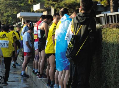 2013年10月20日，北京馬拉松比賽，由于廁位有限，一些選手在綠化帶“就地解決”。圖/IC