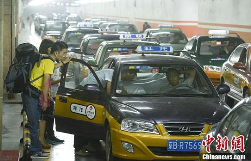 市民在北京西客站出租車候車點(diǎn)準(zhǔn)備乘車。中新社發(fā) 侯宇 攝
