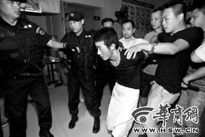 犯罪嫌疑人韓牙某圍著圍裙在廚房內拉面，被民警抓獲 本報記者 鄧小衛 攝