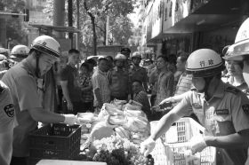 7月11日，瀏陽市北正中路，執法人員暫扣張海的水果。這是瀏陽市城管局拍攝的執法現場圖。