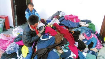 學(xué)生在幫忙整理收到的捐贈(zèng)衣服。得石中心校供圖