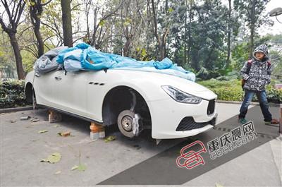 昨日，停放在重慶大學(xué)B區(qū)的一輛瑪莎拉蒂豪車被架在幾塊磚頭上，車輪不翼而飛。 重慶晨報記者 胡杰 攝