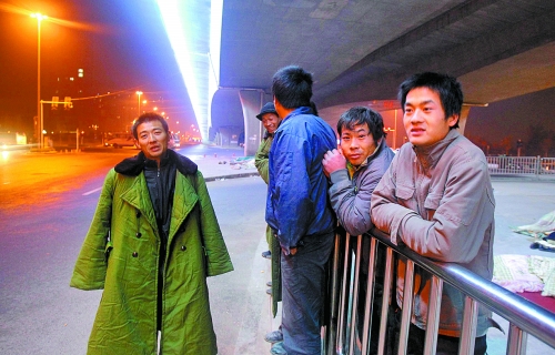 冬夜里，農(nóng)民工在橋下等著干活兒。