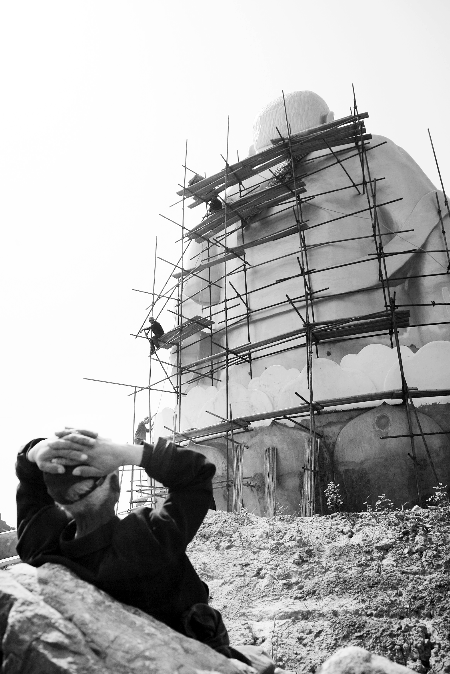 今年4月26日，工作人員將帆布蓋在“佛像”頭像上