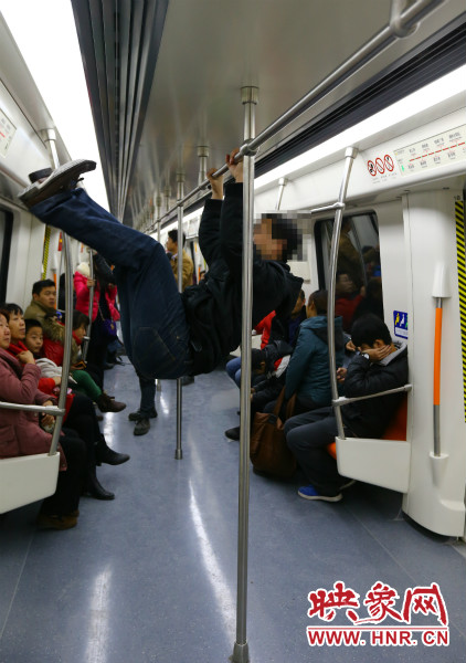 地鐵試乘日，一男子在車廂內(nèi)攀爬扶手自娛自樂