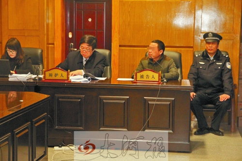 庭審現(xiàn)場，被告人坐在律師身旁為自己辯護(hù)。