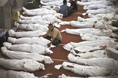 8月15日，在埃及首都開羅的一個清真寺，人們在成排的遺體旁哀悼。