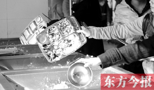 11月27日，河南中醫(yī)學(xué)院餐廳，一名同學(xué)將餐盤內(nèi)沒吃完的食物倒入餐具回收車內(nèi)