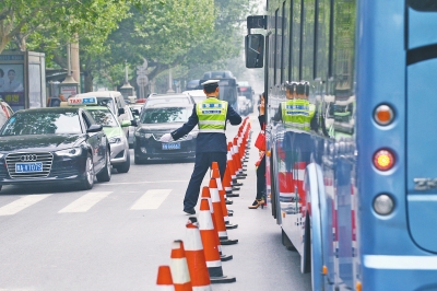 省人民醫院南門的路中間擺放反光錐，交警示意由西向東車輛從前方繞行。