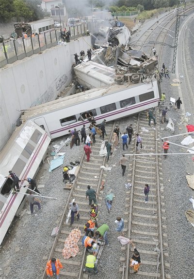 24日，救援人員在西班牙列車(chē)脫軌現(xiàn)場(chǎng)。一節(jié)車(chē)廂被強(qiáng)大的慣性拋上鐵道邊的高臺(tái)。
