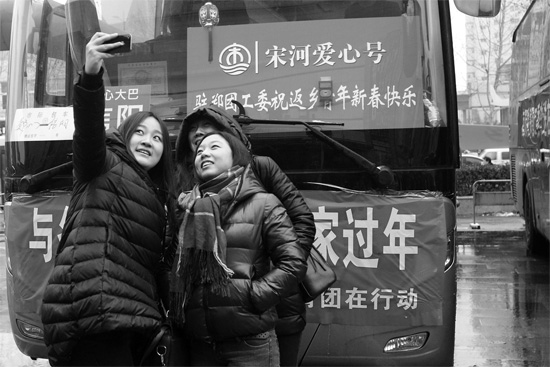 昨天上午8時，鄭州正道中環(huán)百貨廣場，準(zhǔn)備回家的老鄉(xiāng)在愛心大巴車前合影留念