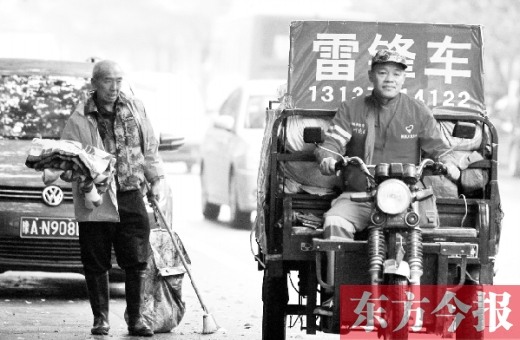 鄭州市商城路，一名環(huán)衛(wèi)工懷抱著剛剛收到的毯子，目送“雷鋒哥”孫德坤離開(kāi)