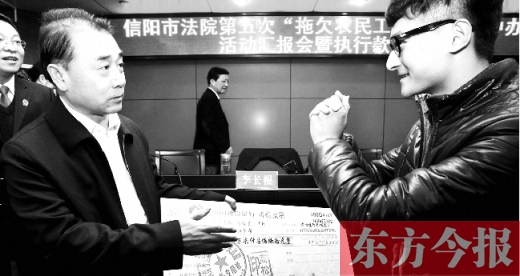 張立勇將依法執行回來的農民工工資發放給案件當事人游昌華，游昌華施以中國傳統作揖禮答謝