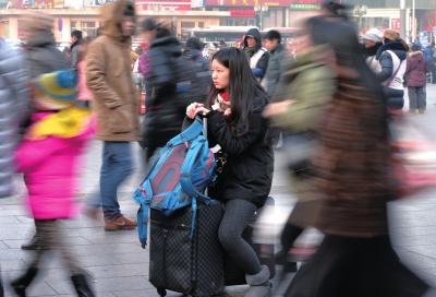 春運(yùn)首日，北京站客流量明顯增多，一名女孩在人流中等待進(jìn)站。