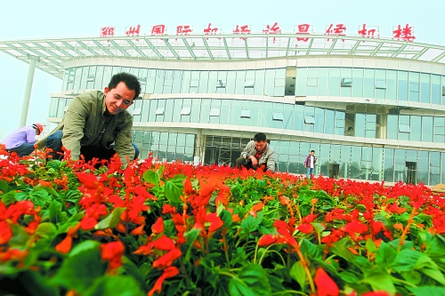 9月23日，工人們正在鄭州國際機場許昌候機樓前擺放鮮花。