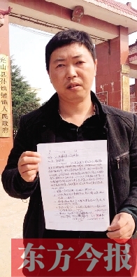 吳大強手持還款協議在鎮政府門前