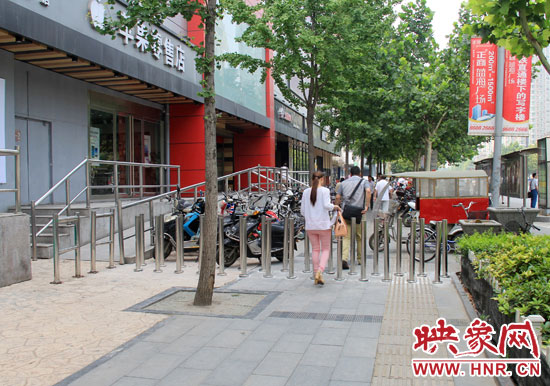 圖中道路左側(cè)的無障礙通道被鋼管隔離,右側(cè)的盲道也被侵占。