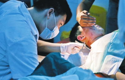 孩子身上有7道傷痕，其中兩道需要縫合，其他的均為擦傷，醫生正對他施治。