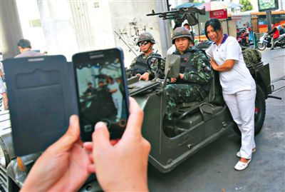 20日，泰國首都曼谷，一名婦女與執行軍管任務的士兵合影。