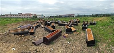 40多副棺木被砸壞后，扔在荒地上。