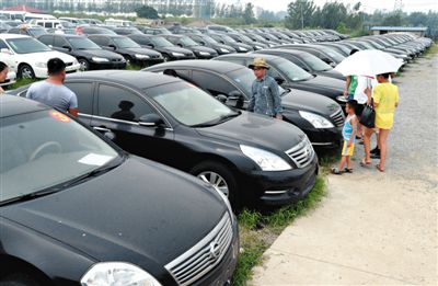 昨日，市民在山東棗莊一家拍賣公司場地上查看待拍賣公車。當日，棗莊市103輛公車公開拍賣。新華社記者