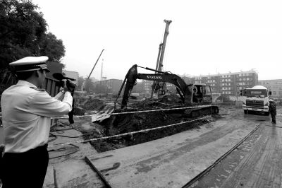 學院南路一科研樓項目有3臺挖掘機違規進行土方作業，被城管隊員當場責令停工。京華時報記者歐陽曉菲攝