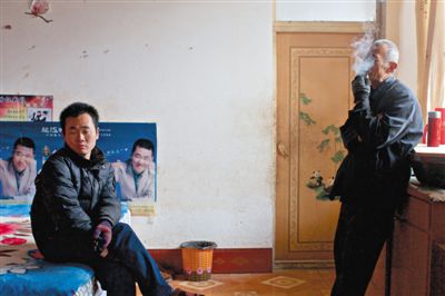 父親抽煙，兒子不語。逃跑的越南新娘，給袁迎賓父子帶來的是失落。新京報記者