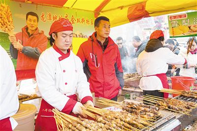 賣(mài)羊肉串?dāng)偽焕习遐w山（穿紅衣者）。新京報(bào)記者