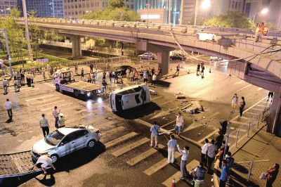 路虎沖下國貿橋砸中一輛起亞轎車，橋上厚達幾十厘米的水泥護欄被撞斷，碎石四處散落，數十群眾在現場圍觀。