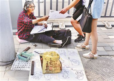 八旬老太路邊擺攤賣畫稱養家