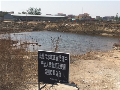 化肥廠滲坑的三分之一經過治理，但水質仍然呈黃褐色。