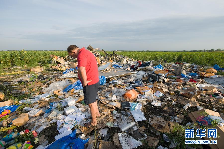 　7月19日,在烏克蘭頓涅茨克州,一名當地民眾站在馬航MH17航班墜機現場。