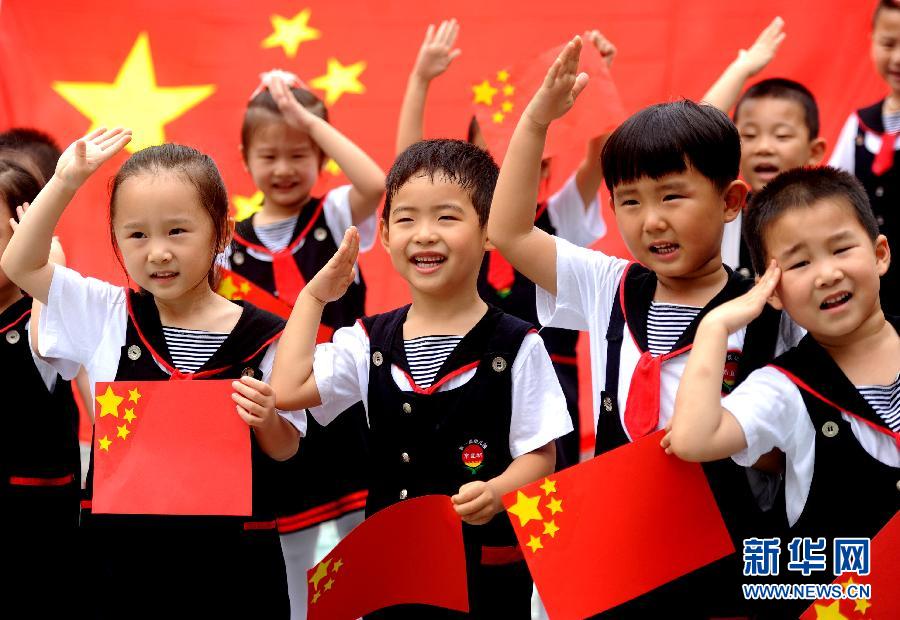  9月28日，安徽淮南市直機關幼兒園的小朋友在國旗前唱《國歌》，慶祝祖國65周歲生日。
