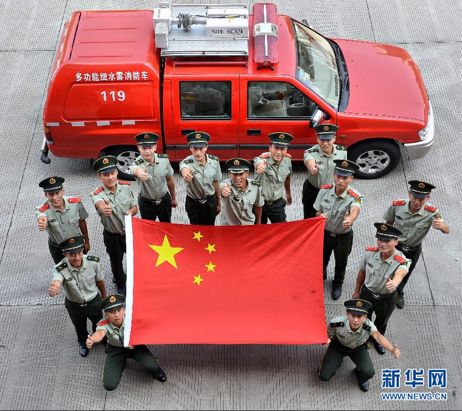  9月25日，武警浙江嘉興消防官兵與國旗合影。