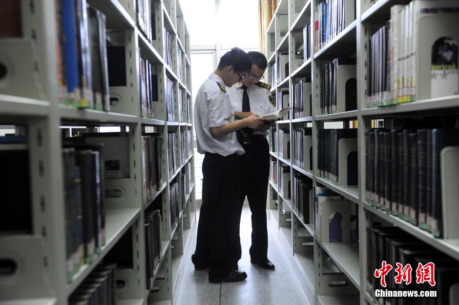 5月8日，武漢輕工大學(xué)保安吳濤與江力在圖書館交流學(xué)習(xí)。中新社發(fā) 張暢 攝