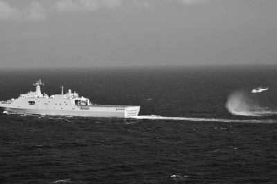 11日，抵達馬航飛機失聯海區的海軍井岡山艦與艦載直升機協同展開立體搜救行動。新華社發