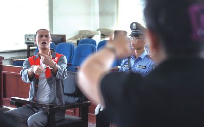 張志國(guó)在法庭上用手語(yǔ)回答提問(wèn)。記者 蒲東峰攝