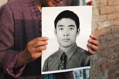 5月19日，朝陽(yáng)北路，母親捧著張東文的遺像。新京報(bào)記者 侯少卿 攝