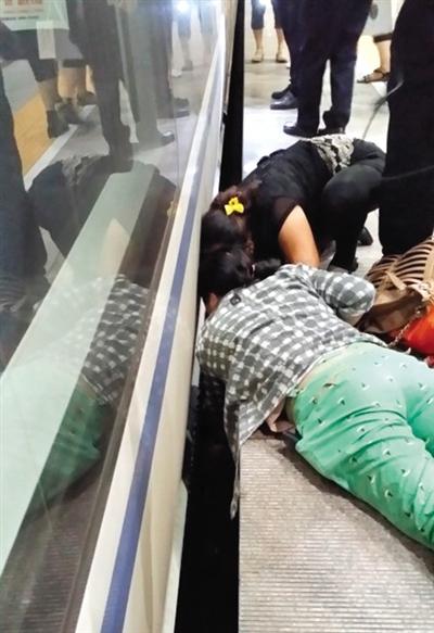 一女子趴在站臺(tái)上，救跌入列車和站臺(tái)間隙的男童。網(wǎng)友璀璨的星月夜 攝