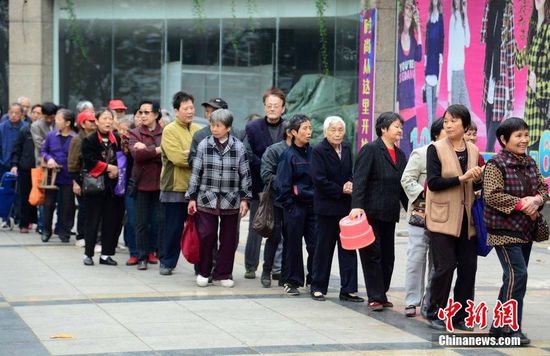 圖為10月28日，在江西九江市一家羊絨皮草服裝服飾博覽會現場，老人們正在頂著寒風排隊等待領取10元代金劵。