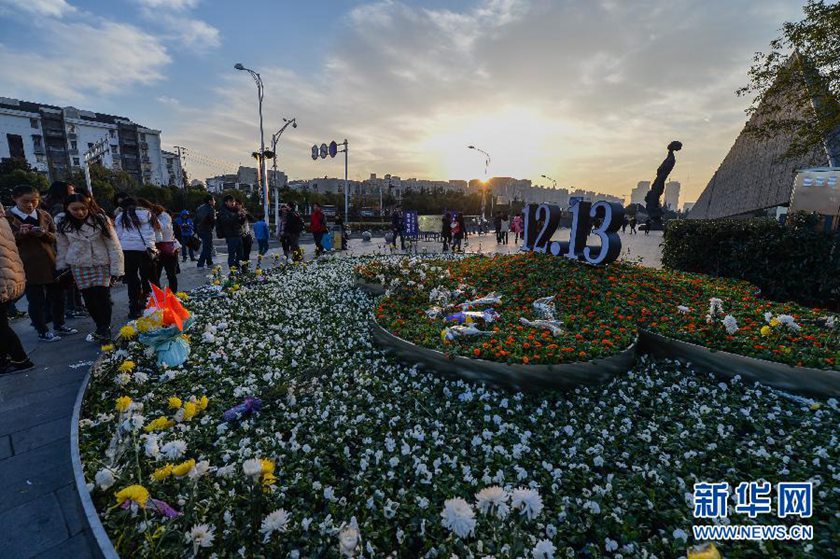 12月14日,觀眾在侵華日軍南京大屠殺遇難同胞紀念館前的“12·13”花壇上擺放鮮花祭奠遇難同胞。新華社記者 沈鵬 攝